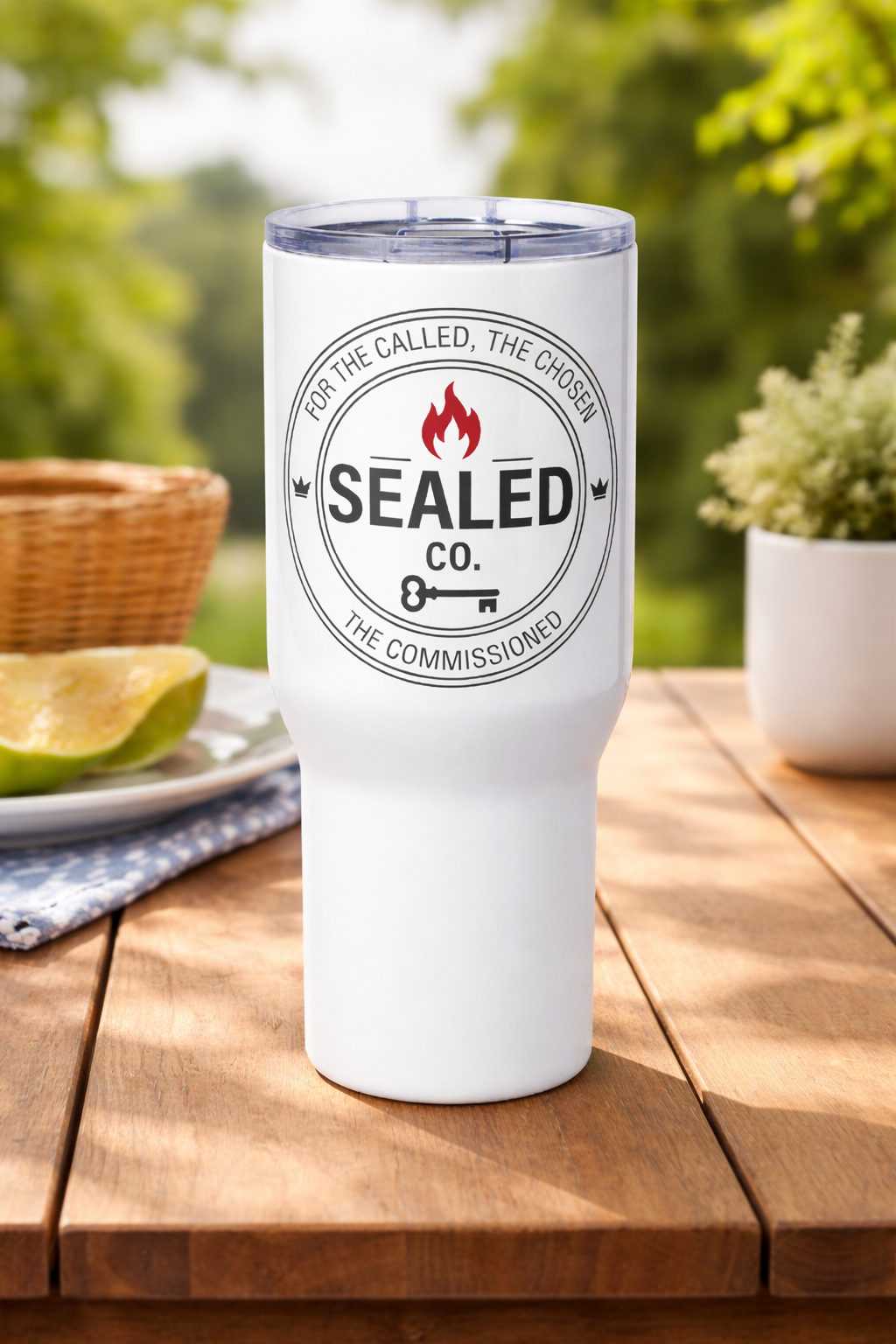 White 40 oz Christian travel mug with handle featuring partial SEALED Co. logo on desk beside laptop and coffee cup